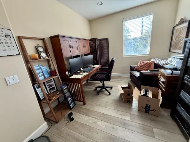 a view of a workspace with furniture and a window