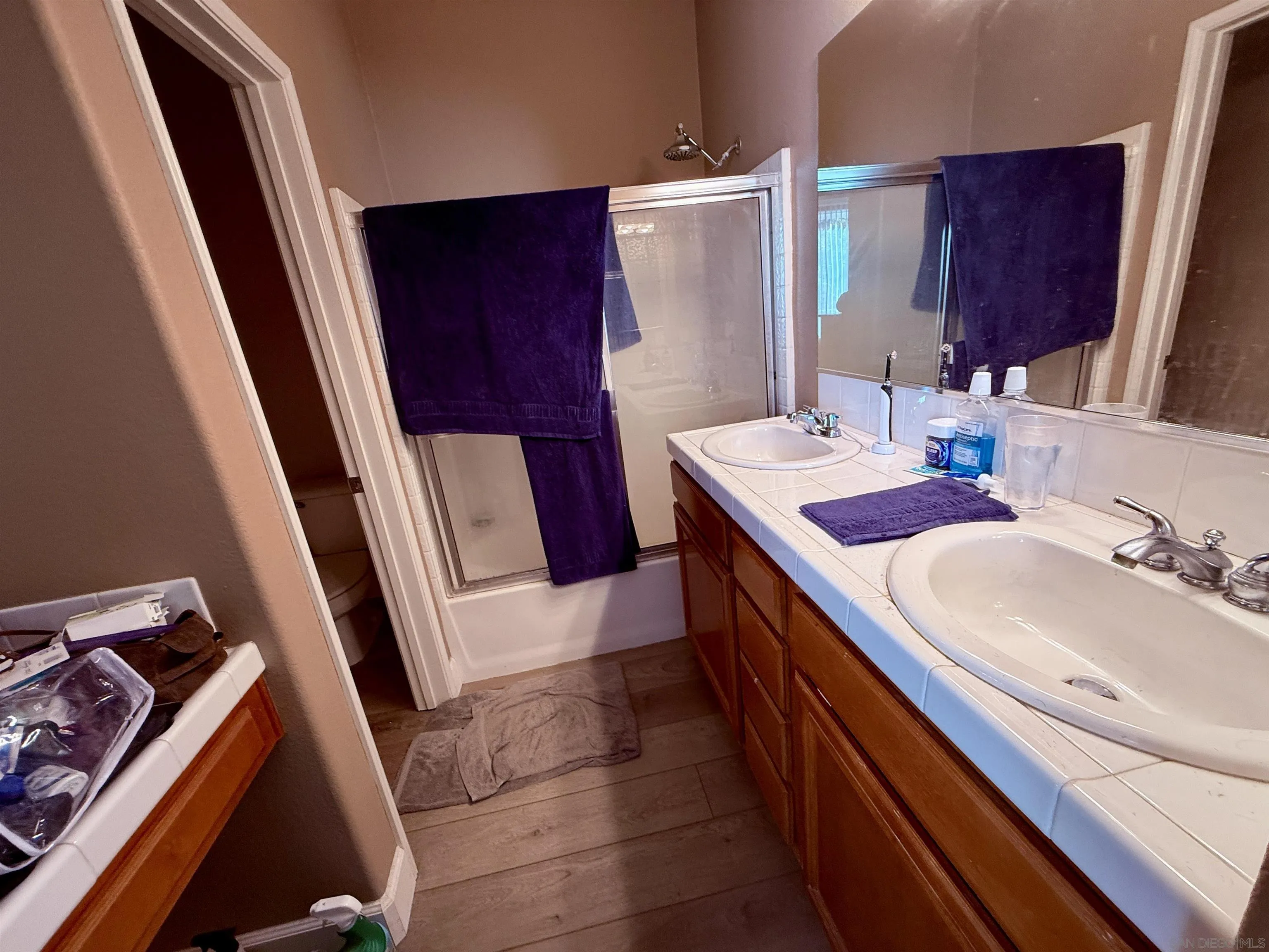 6471 Terraza Portico Carlsbad, CA 92009 - Photo 7 of 19 a bathroom with a sink a toilet a mirror and vanity