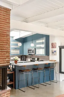 a kitchen with a sink a counter and chairs