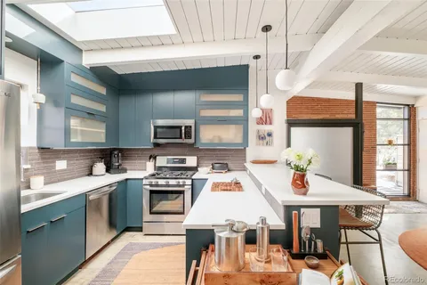 a kitchen with a sink a stove and chairs