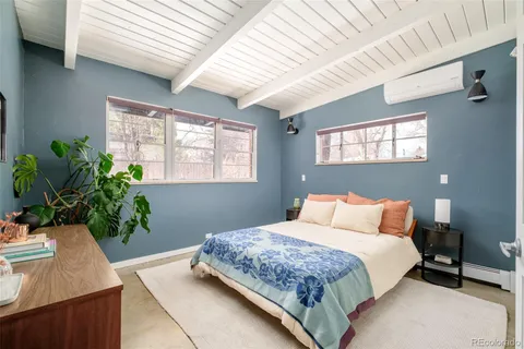 a bedroom with a large bed and a potted plant