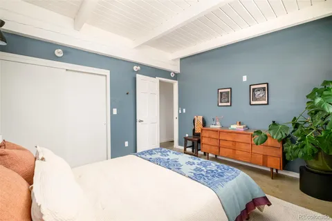 a bedroom with bed and wooden floor