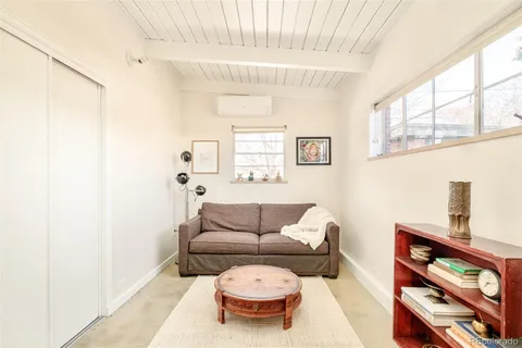 a living room with furniture and a painting on the wall