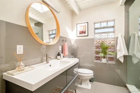 a bathroom with a toilet a sink and a mirror