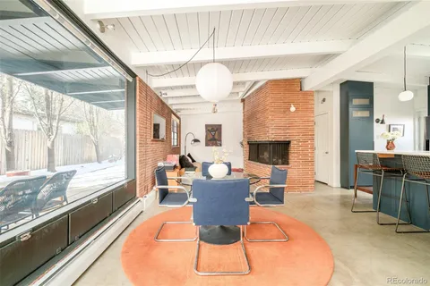 a living room with fireplace furniture and a large window