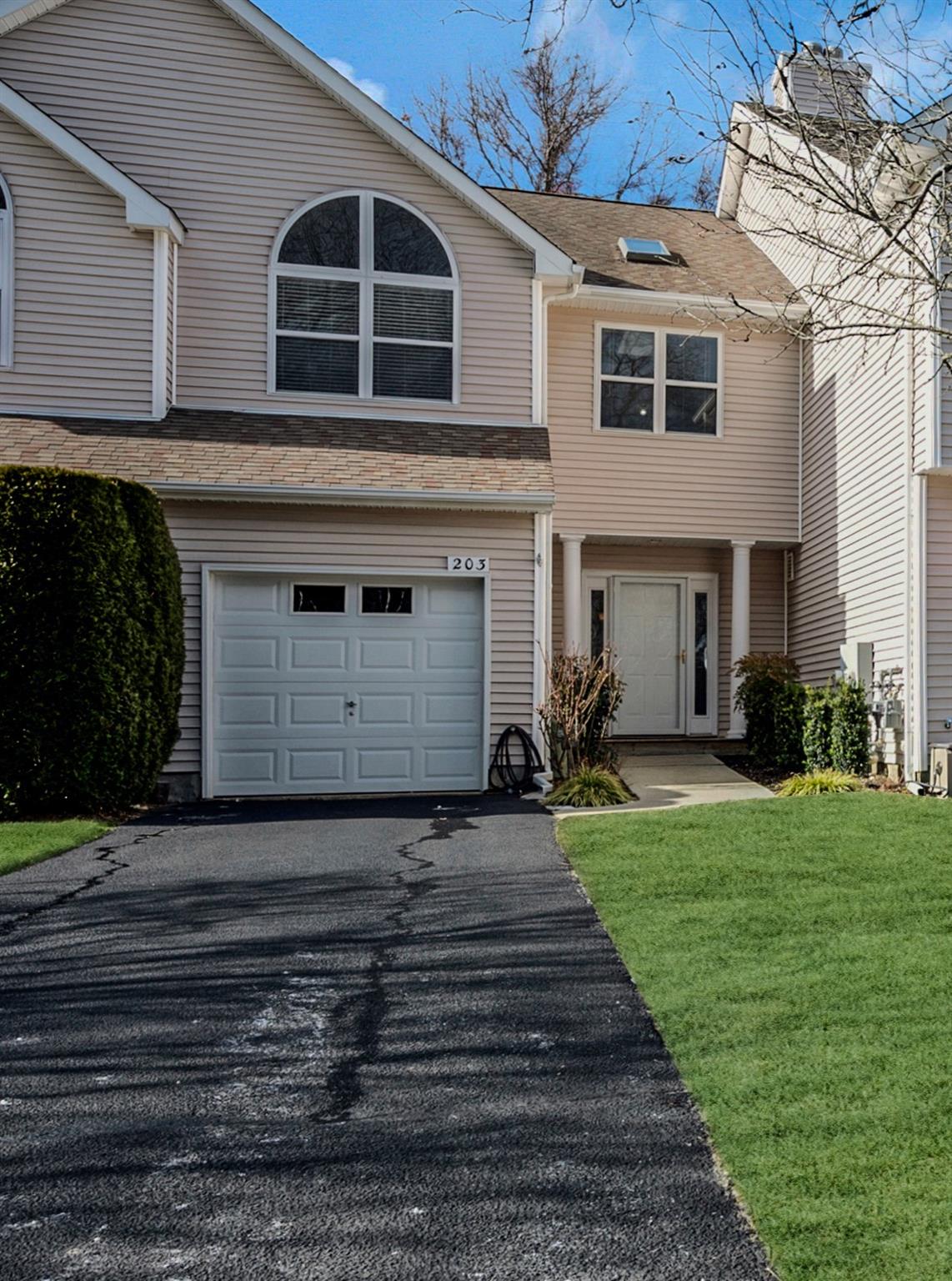 View of front of home with a garage and a front yard