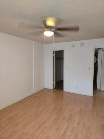 a view of an empty room with a chandelier fan