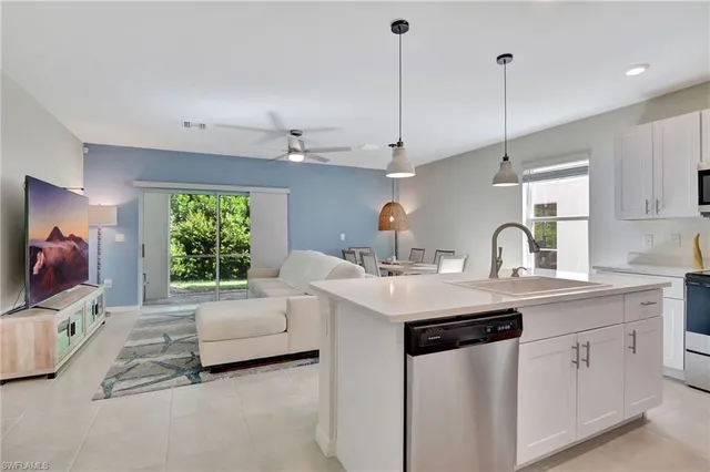 a view of a kitchen with kitchen island a sink stainless steel appliances and living room view