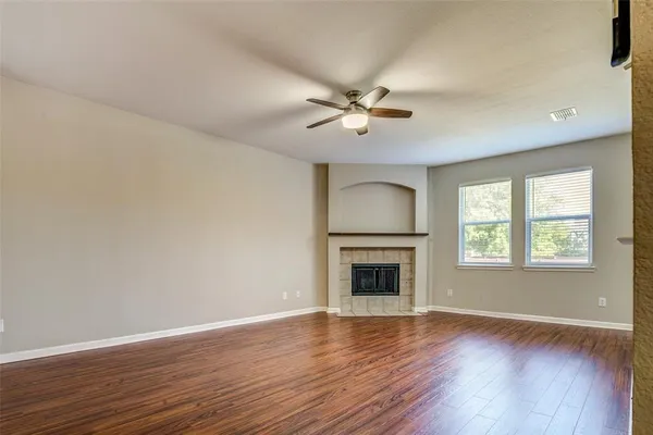 a view of empty room with a fireplace and wooden floor