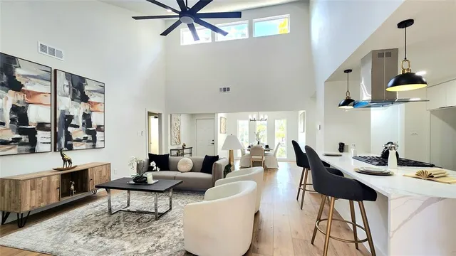 a living room with furniture kitchen view and a chandelier
