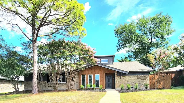 a front view of a house with a yard garage and tree