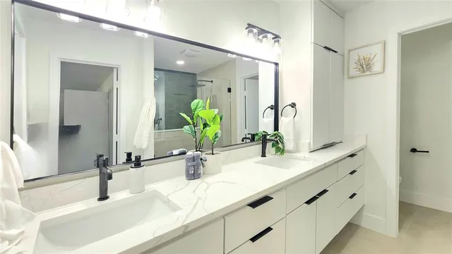 a bathroom with double vanity sink and a mirror