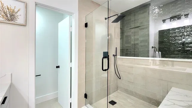 a bathroom with a shower and a glass door