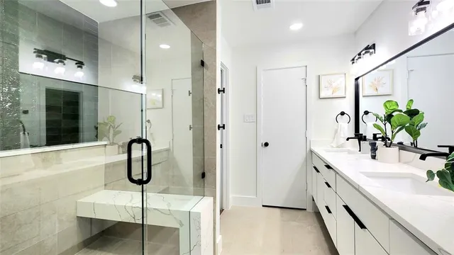 a bathroom with a double vanity sink a mirror a bathtub and shower