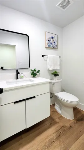 a bathroom with a toilet a sink and mirror