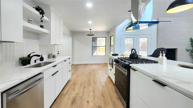 a kitchen with granite countertop a sink stove and cabinets