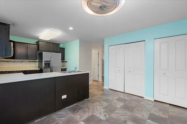 a kitchen with stainless steel appliances a sink a stove a refrigerator and cabinets