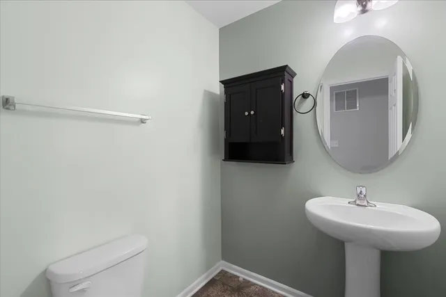 a bathroom with a sink toilet and mirror