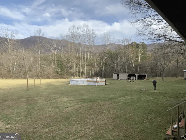 a view of a field of grass and trees