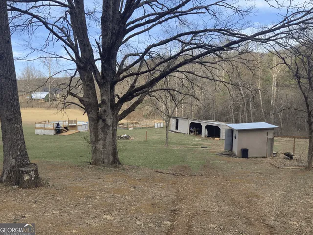 a view of a backyard with lawn chairs and iron fence