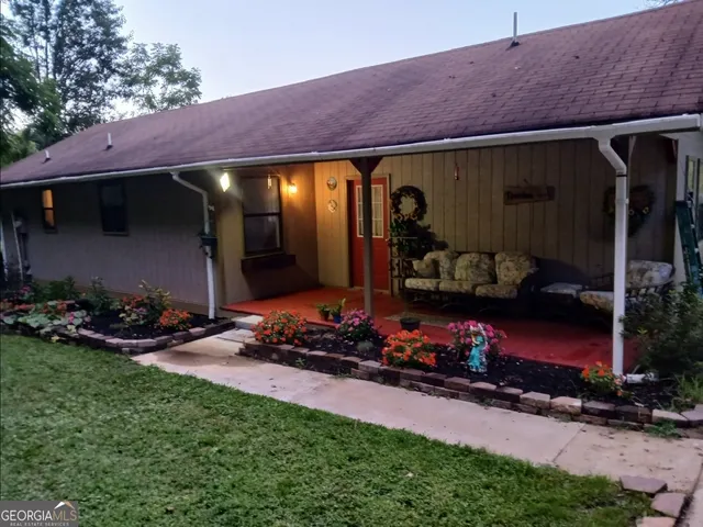 a view of a backyard with chairs and potted plants
