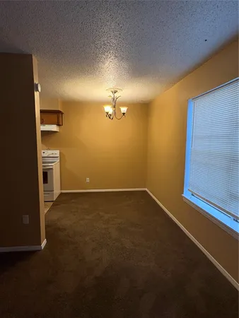 a view of a livingroom with an empty space and a refrigerator