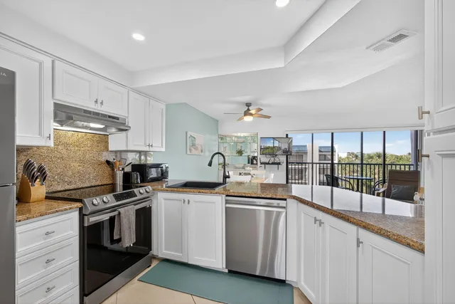 a kitchen with a refrigerator sink stove and cabinets