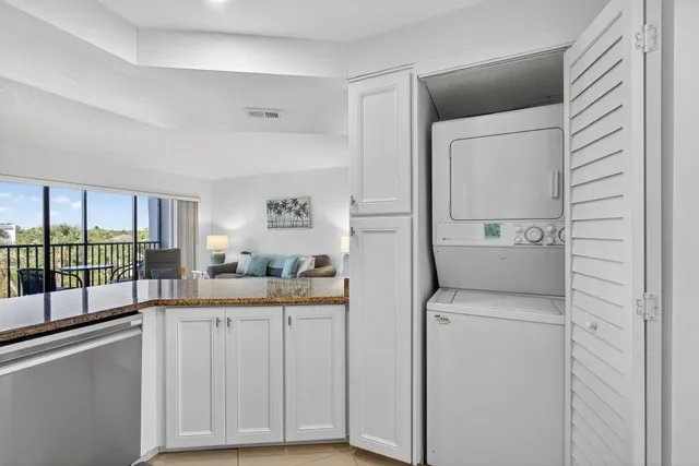 a kitchen with stainless steel appliances kitchen island granite countertop a dining table chairs and a refrigerator