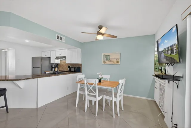 a kitchen with stainless steel appliances kitchen island granite countertop a table and chairs in it