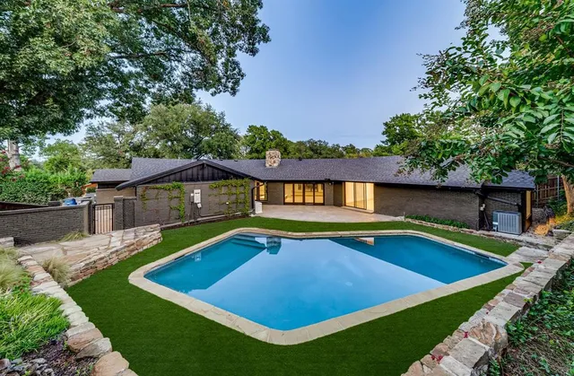 a view of an house with swimming pool and yard