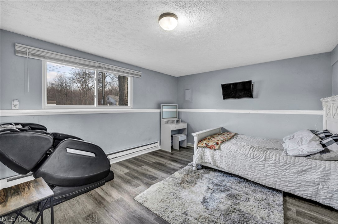 54 Park Road Painesville, OH 44077 - Photo 20 of 38 Bedroom with dark wood-style flooring, a textured ceiling, and a baseboard heating unit