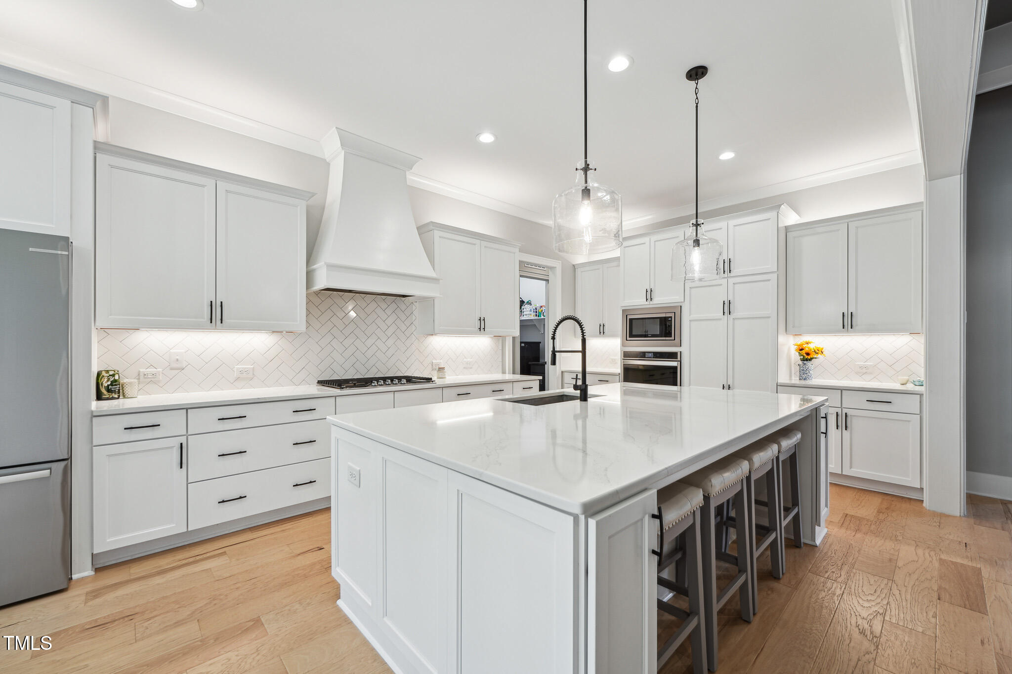3545 Donlin Drive Wake Forest, NC 27587 - Photo 14 of 62 a kitchen with a sink stove a refrigerator and white cabinets with wooden floor