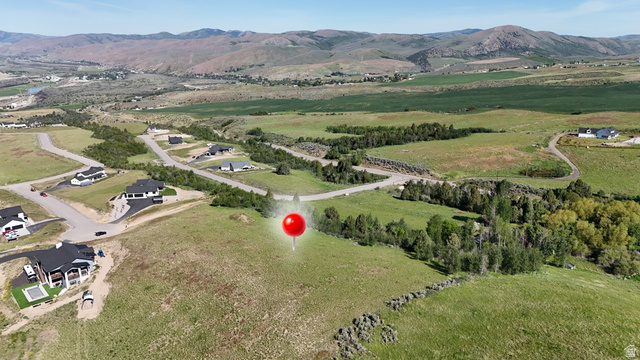 Expansive green landscape featuring varied topography with distant mountains