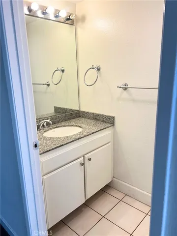 a bathroom with a granite countertop sink mirror and vanity