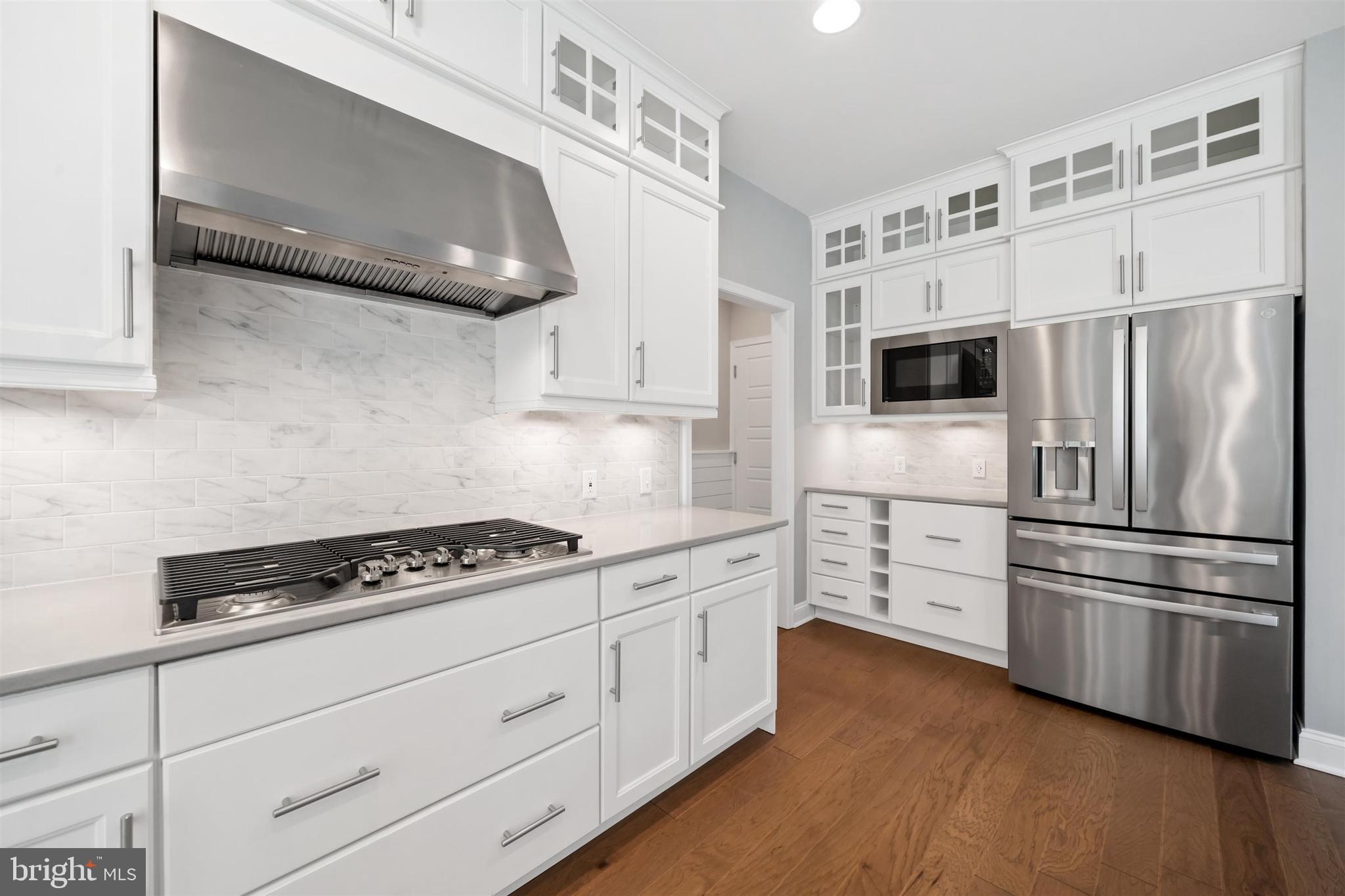 22144 Welches Way Lewes, DE 19958 - Photo 18 of 77 a kitchen with stainless steel appliances a refrigerator stove and white cabinets