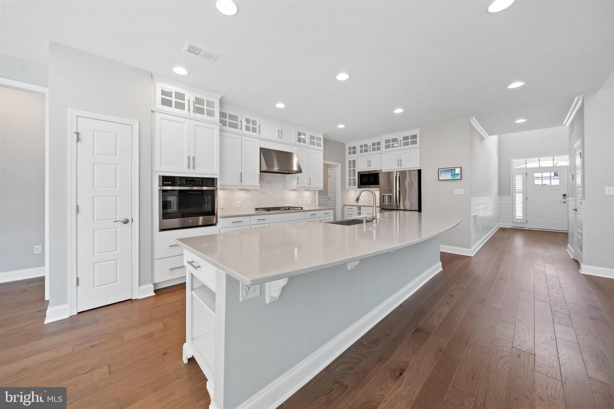 22144 Welches Way Lewes, DE 19958 - Photo 19 of 77 a kitchen with stainless steel appliances kitchen island granite countertop a refrigerator a sink dishwasher a oven with white cabinets and wooden floor