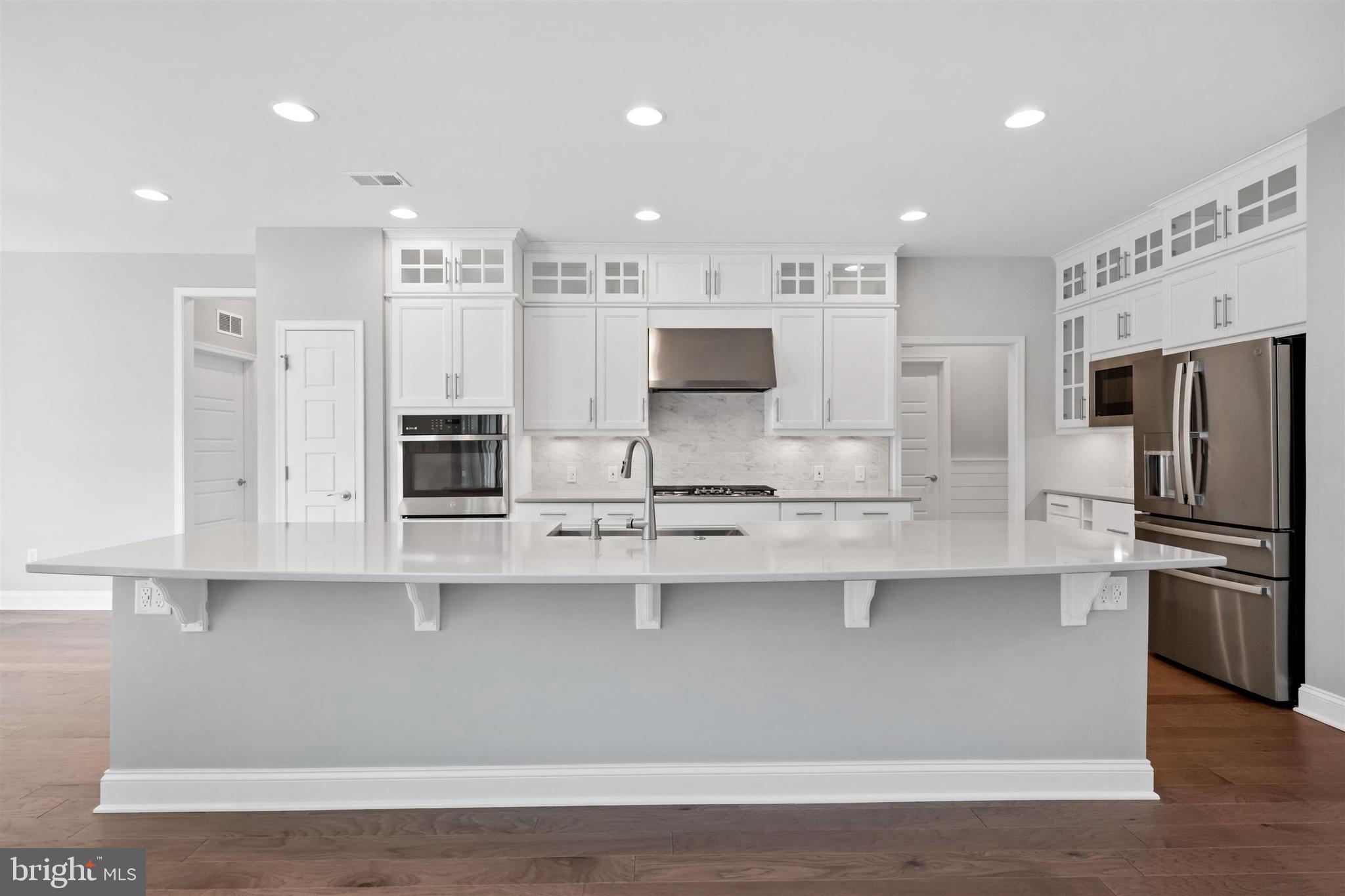 22144 Welches Way Lewes, DE 19958 - Photo 20 of 77 a kitchen with stainless steel appliances granite countertop a sink a stove a refrigerator and white cabinets