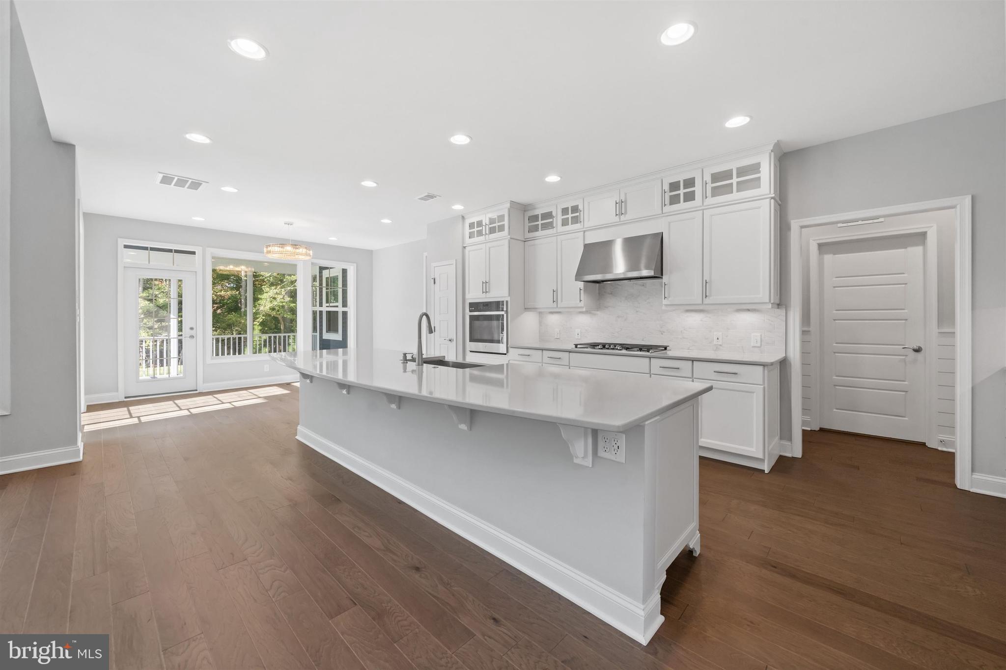 22144 Welches Way Lewes, DE 19958 - Photo 10 of 77 a large kitchen with granite countertop a large counter top a sink stainless steel appliances and cabinets