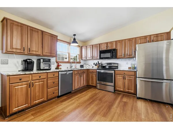 a kitchen with granite countertop stainless steel appliances and wooden cabinets