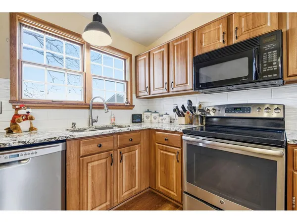 a kitchen with stainless steel appliances granite countertop a sink stove and microwave