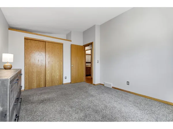a view of an empty room with window and bathroom