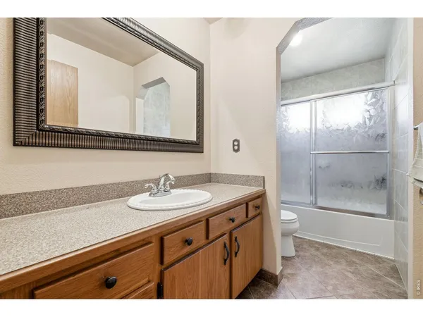 a bathroom with a toilet a sink a mirror and a shower