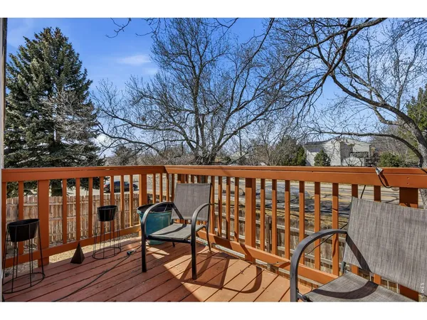 a balcony with wooden floor outdoor seating and trees