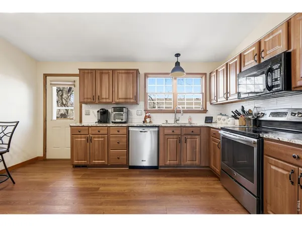 a kitchen with stainless steel appliances granite countertop a stove a sink and a microwave