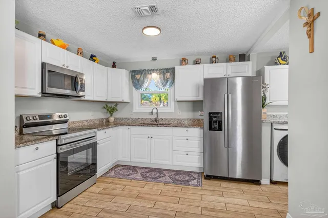 a kitchen with stainless steel appliances granite countertop a refrigerator sink and stove
