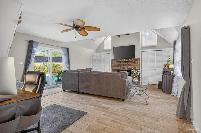 a living room with furniture a flat screen tv and a fireplace