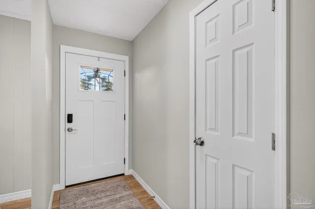 a view of a hallway with wooden floor and closet