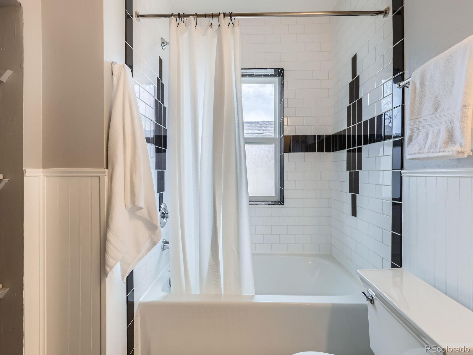 3833 Umatilla Street Denver, CO 80211 - Photo 28 of 50 a bathroom with a bathtub and a shower