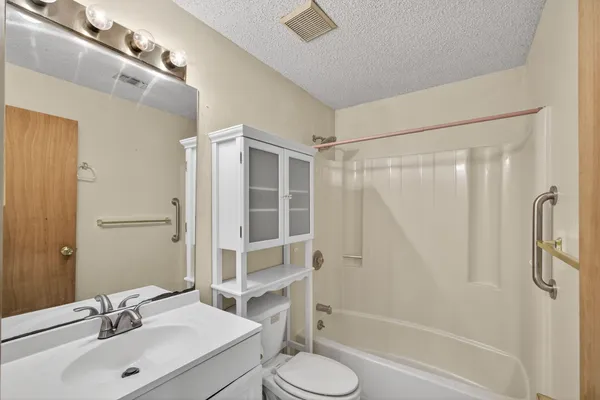 a bathroom with a double vanity sink toilet mirror and shower