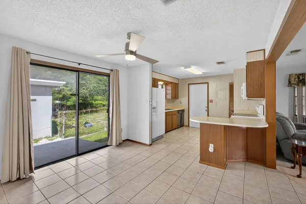 a living room with furniture a dining table and chairs with kitchen view